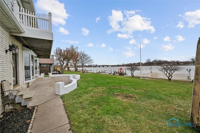 view of yard with a water view and a patio area