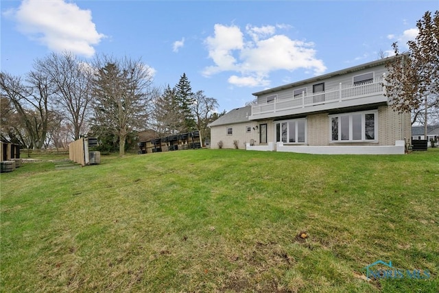 back of house with a yard and a balcony