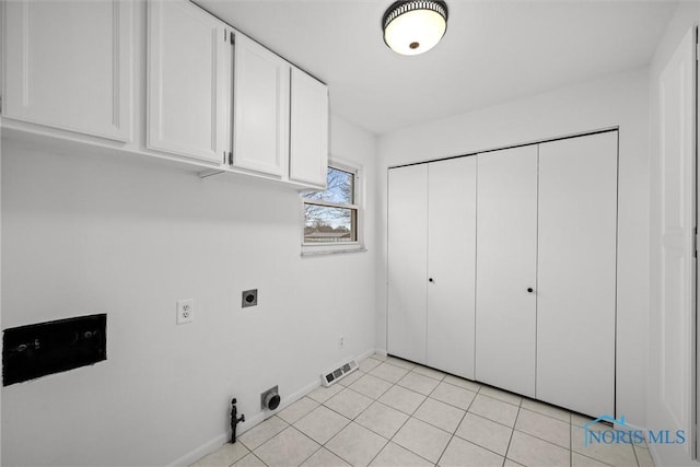 laundry area featuring hookup for an electric dryer, hookup for a gas dryer, cabinets, and light tile patterned floors