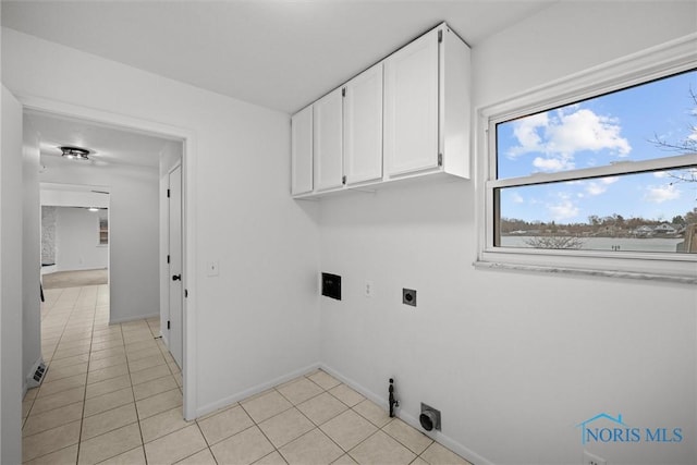 laundry room with cabinets, light tile patterned floors, hookup for a gas dryer, and hookup for an electric dryer