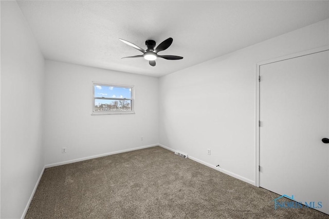 carpeted spare room with ceiling fan