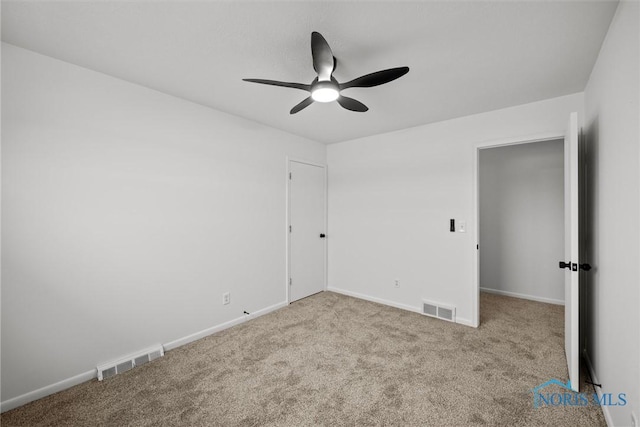 carpeted spare room with ceiling fan