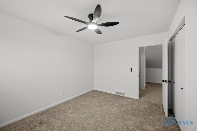 spare room with ceiling fan and light carpet