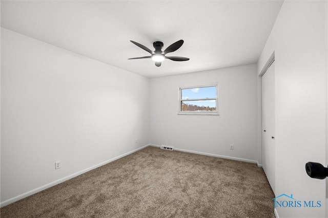 carpeted spare room with ceiling fan