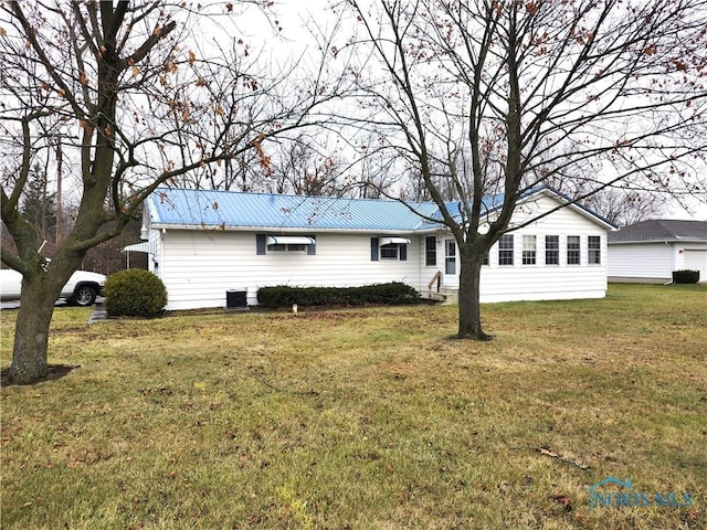 rear view of house featuring a lawn