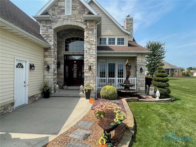 view of exterior entry with a lawn