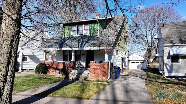 view of front of house featuring a front yard, covered porch, an outdoor structure, and a garage