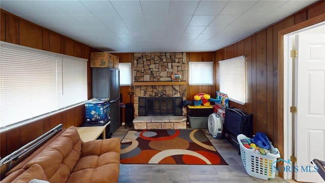 living room with a fireplace and wooden walls