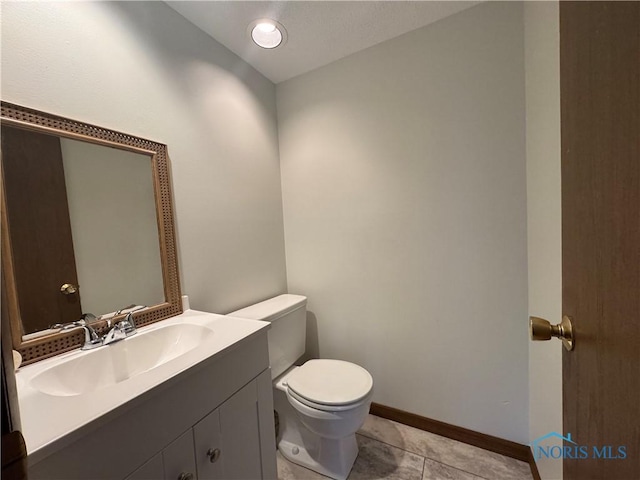 bathroom with tile patterned flooring, vanity, and toilet