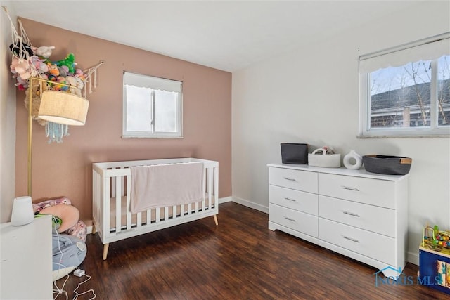 bedroom with dark hardwood / wood-style flooring and a nursery area