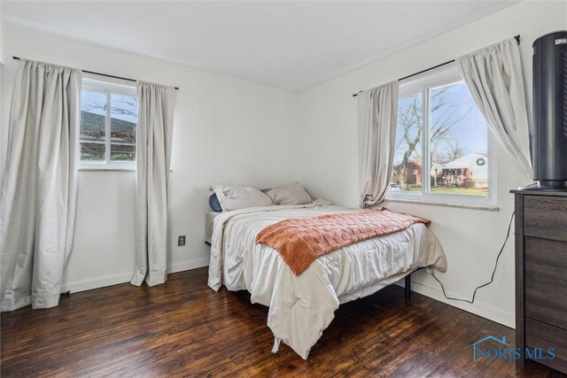 bedroom with dark hardwood / wood-style floors