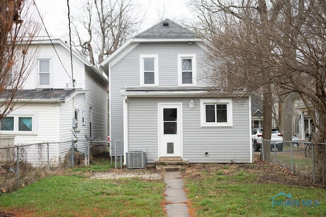 rear view of house with a yard and central AC unit