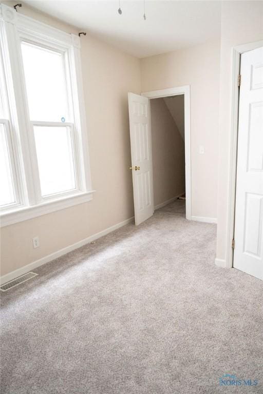 carpeted empty room featuring a wealth of natural light