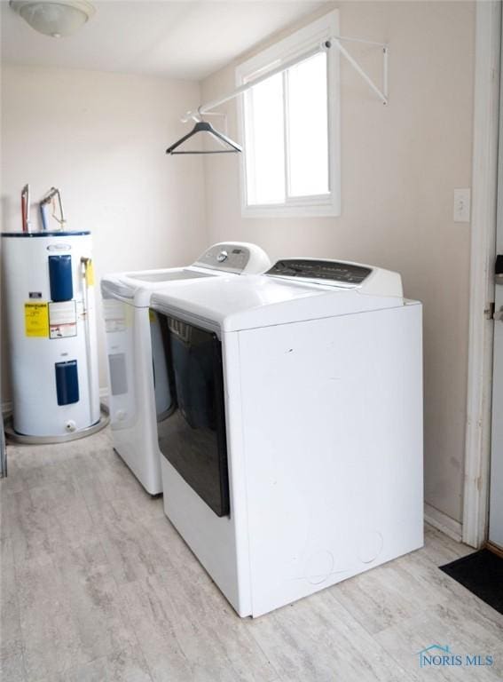 clothes washing area with electric water heater, light hardwood / wood-style flooring, and independent washer and dryer