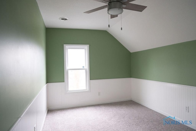 additional living space with light colored carpet, vaulted ceiling, and ceiling fan