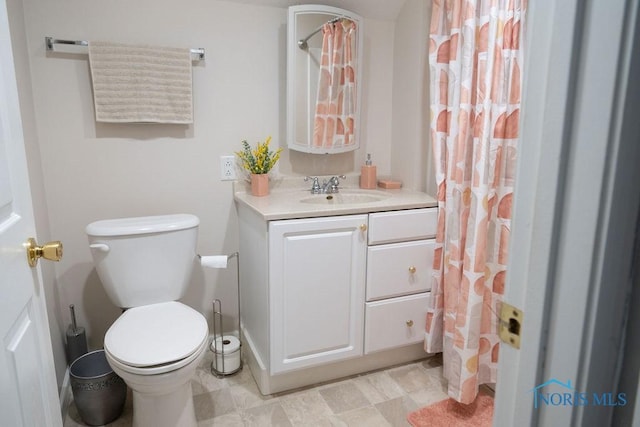 bathroom with vanity, toilet, and curtained shower