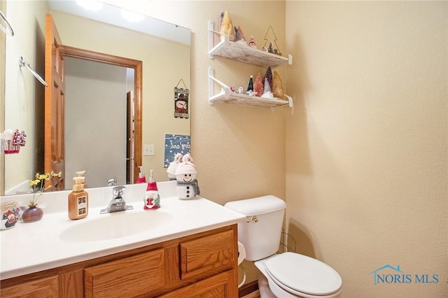 bathroom featuring vanity and toilet