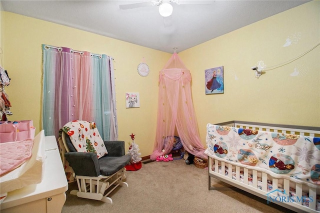 bedroom with ceiling fan, carpet, and a nursery area