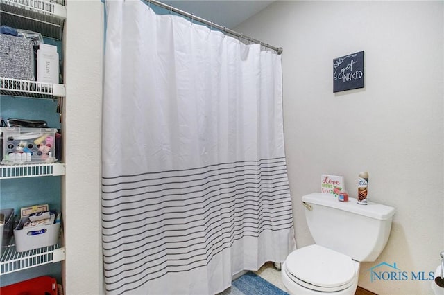 bathroom featuring curtained shower and toilet