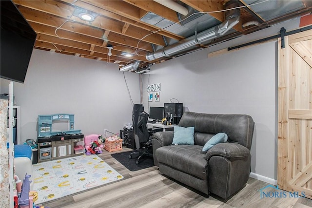 home office featuring a barn door and wood-type flooring