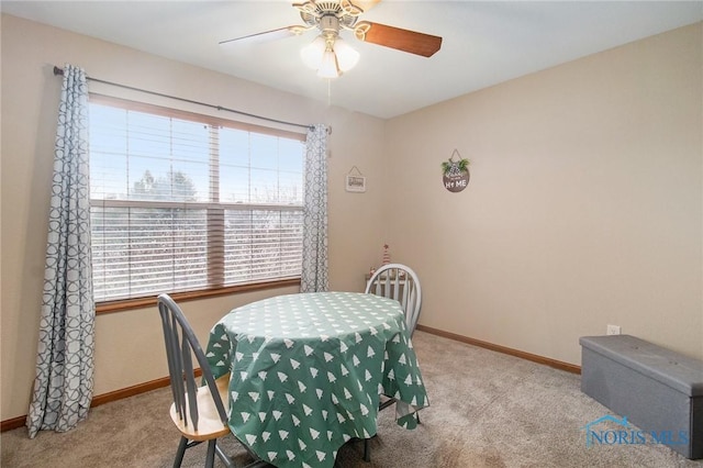 carpeted dining room featuring ceiling fan