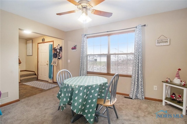 carpeted dining space with ceiling fan