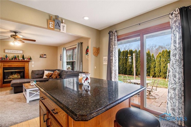 kitchen with plenty of natural light, a kitchen island, ceiling fan, and light hardwood / wood-style flooring