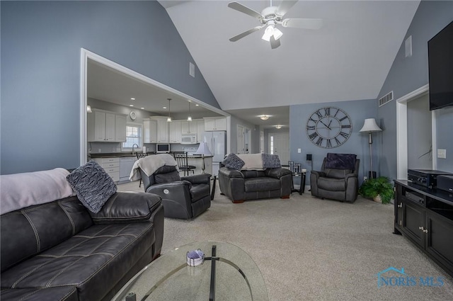 carpeted living room featuring ceiling fan and high vaulted ceiling