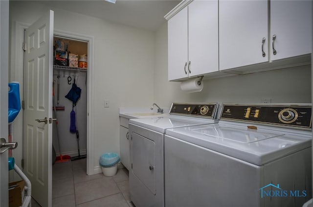 laundry room featuring separate washer and dryer, sink, light tile patterned floors, and cabinets