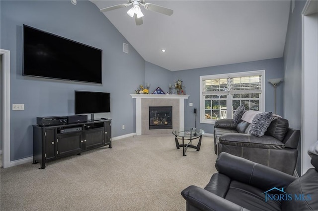 living room featuring ceiling fan, lofted ceiling, light carpet, and a tiled fireplace