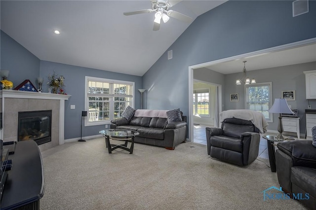 living room featuring light carpet, ceiling fan with notable chandelier, high vaulted ceiling, and a fireplace