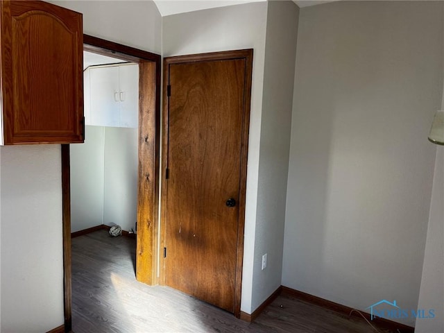 corridor with dark hardwood / wood-style flooring