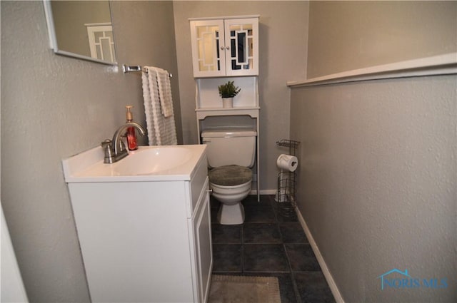 bathroom featuring tile patterned flooring, vanity, and toilet