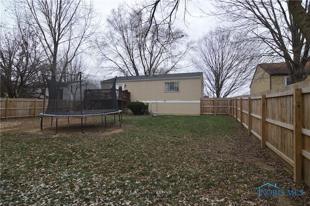 view of yard with a deck and a trampoline