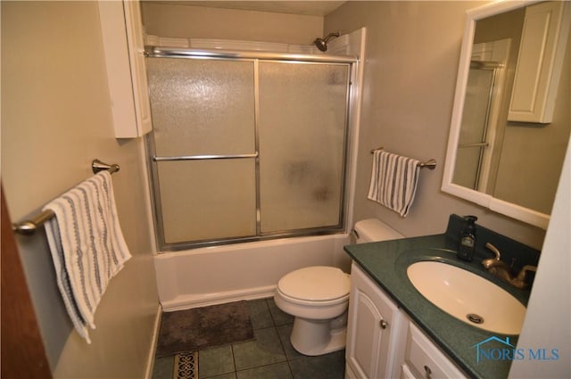 full bathroom with tile patterned floors, vanity, enclosed tub / shower combo, and toilet