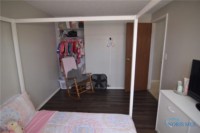 bedroom featuring a closet and dark wood-type flooring