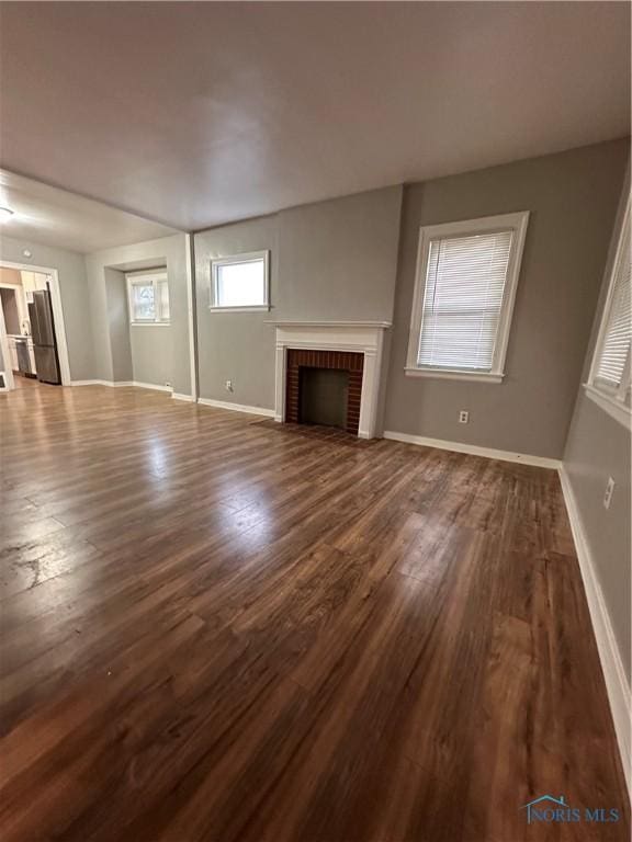 unfurnished living room with dark hardwood / wood-style floors and a fireplace