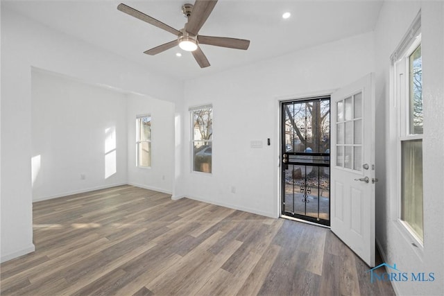 empty room featuring hardwood / wood-style flooring, plenty of natural light, and ceiling fan