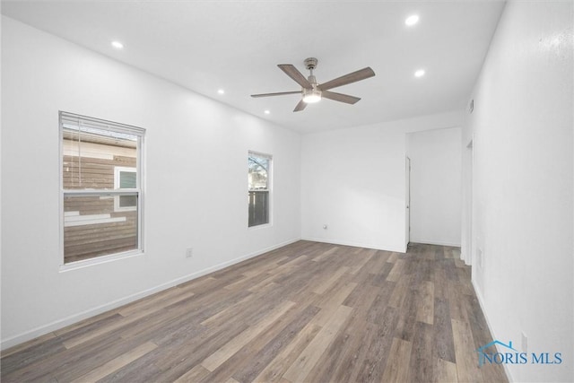 empty room with hardwood / wood-style flooring, ceiling fan, and a healthy amount of sunlight