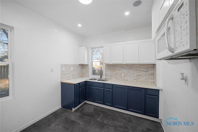 kitchen with backsplash, white cabinetry, a healthy amount of sunlight, and sink