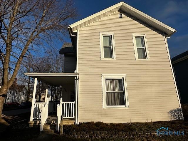 back of property featuring covered porch