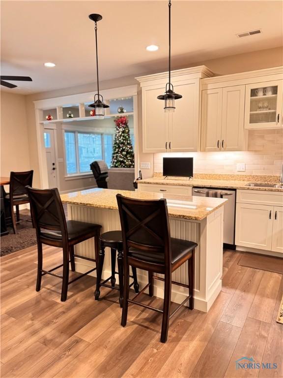 bar with dishwasher, pendant lighting, white cabinets, and sink