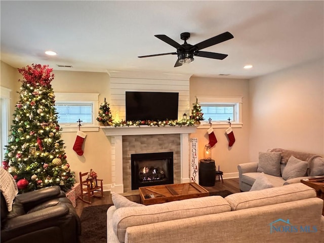 living room with hardwood / wood-style flooring, plenty of natural light, ceiling fan, and a tiled fireplace