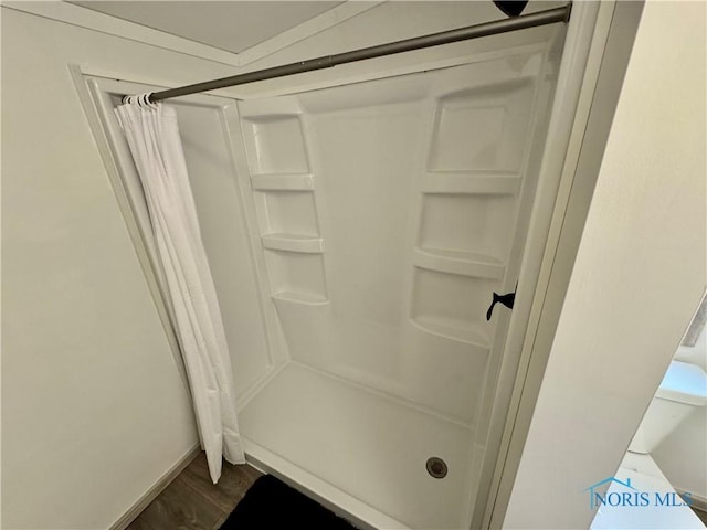 bathroom with a shower with shower curtain and hardwood / wood-style flooring