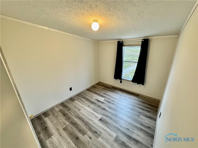 empty room with crown molding, hardwood / wood-style floors, and a textured ceiling