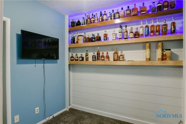 bar with a textured ceiling and dark carpet