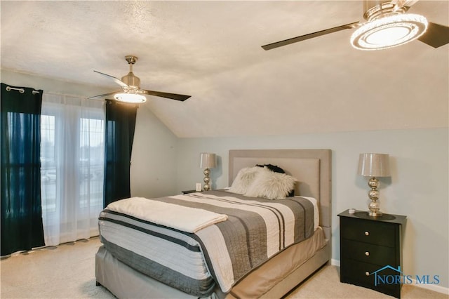 carpeted bedroom featuring a textured ceiling, ceiling fan, and lofted ceiling