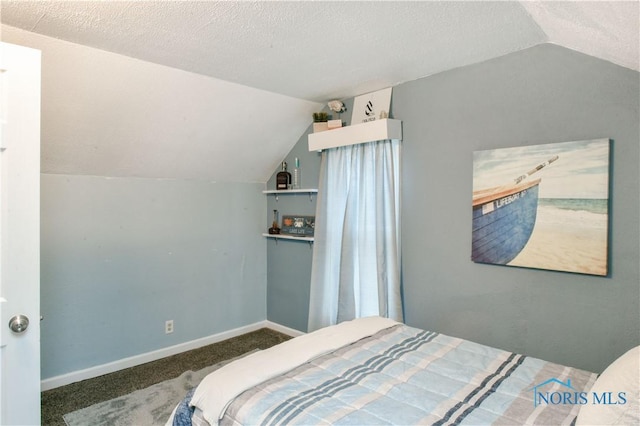 bedroom featuring dark colored carpet, a textured ceiling, and lofted ceiling