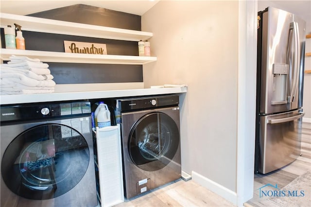 washroom featuring washing machine and dryer and wood-type flooring