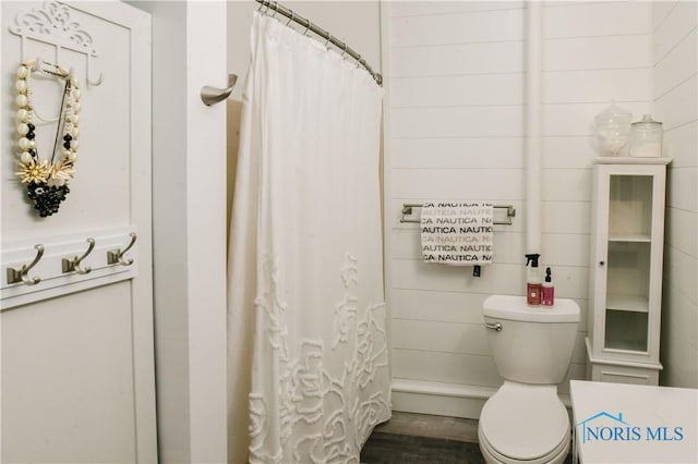 bathroom with a shower with curtain and toilet